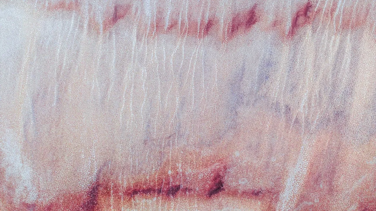 A sandy rusty type texture. Shades of red and light beige, with hints of blue.