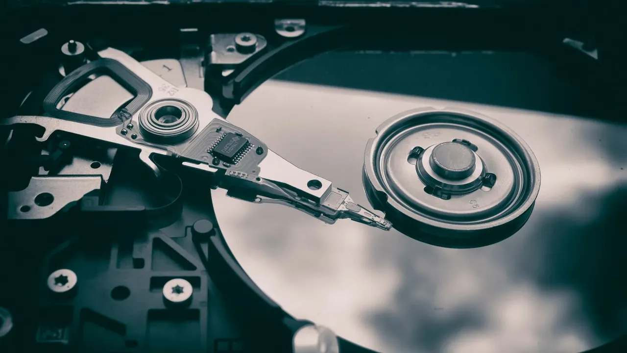 Exposed hard drive platter with read/write arm.